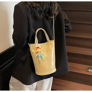 Sac seau beige chic avec un charm de poupée de dessin animé et bandoulière en cuir