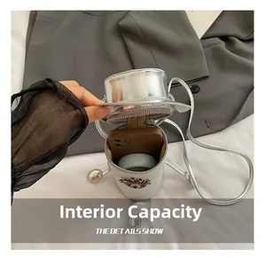 Internal capacity of silver mini cylinder bag showing storage for phone and earphones
