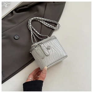 Dettaglio della trama a onde argentate e della fibbia a fiore sulla mini borsa a scatola
