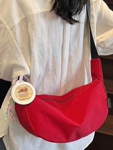 Sac bandoulière rouge en forme de demi-lune avec sangle réglable et pendentif