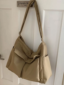 Large khaki canvas crossbody messenger bag with multiple pockets for travel use