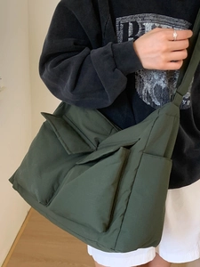 Large dark green canvas messenger bag with multiple pockets and wide shoulder strap