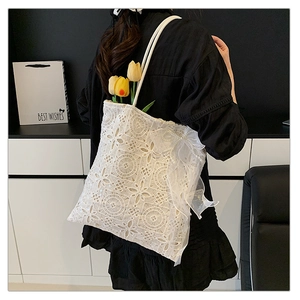 Dettaglio della borsa tote in pizzo bianco con ricami floreali e dettagli in perle