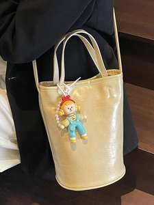 Sac seau minimaliste crème pour femme avec inscription mode et charmant pendentif
