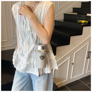 Detail of silver robot crossbody bag with glitter finish and rhinestone eyes decoration
