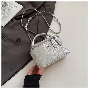 Dettaglio della mini borsa a scatola argento leopardata con manico in metallo e catena