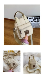 Detailed view of beige nylon crossbody bag with brown leather logo and front zipper pocket