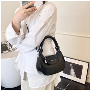 Close-up of black crescent shoulder bag with thick padded handle and brand logo details