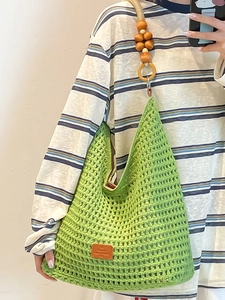 Handmade green crochet hobo bag with wooden beads and woven mesh pattern for beach