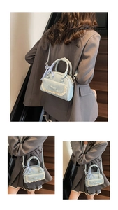 Detail der hellblauen Handtasche mit Spitzendekor und karierter Schleife am Griff