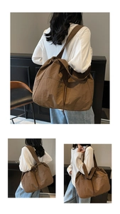 Detail view of large brown nylon tote bag with drawstring closure and outer pocket
