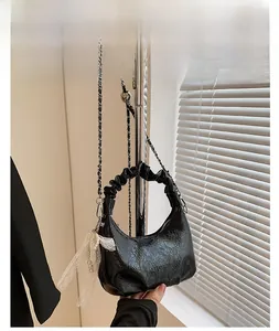 Détail du sac nuage noir brillant avec texture plissée et nœud en dentelle blanche