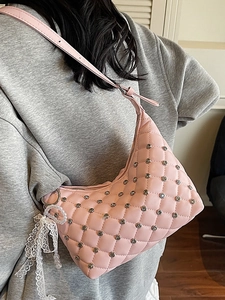 Pink quilted half-moon shoulder bag with silver studs and lace pearl charm on female model