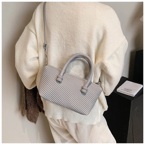 Fashionable gray textured square handbag shown with a long adjustable shoulder strap