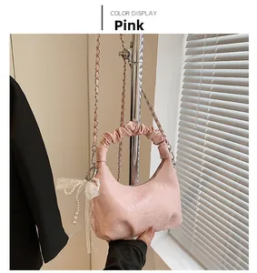 Vue détaillée du sac à bandoulière rose froncé avec nœud en dentelle et chaîne métallique