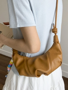 Caramel brown gathered leather croissant bag with colorful beads and knotted strap