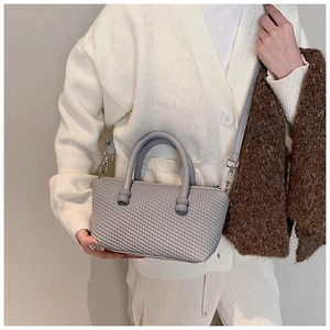 Close-up of gray woven texture handbag with unique spherical handle and strap