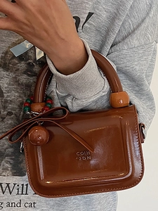 Borsa a mano marrone lucida con ciondoli a farfalla e perline per streetwear primavera 2025