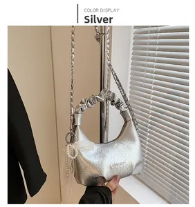 Détail du sac nuage argenté métallisé avec poignée froncée et chaîne à breloques perles