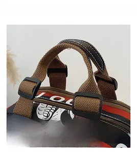 Détail de la poignée tressée marron et boucle en plastique noir sur sac imprimé coloré