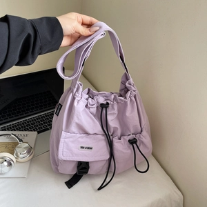 Detail of lavender nylon tote bag with drawstring closure and front buckle pocket design