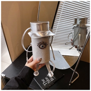 Detailed view of silver robot-shaped crossbody bag with rhinestones and evil eye emblem