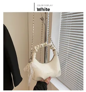 Détail du sac nuage crème avec poignée froncée, chaîne en métal et breloque perle