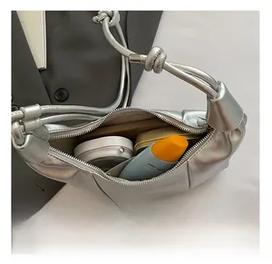 Silver pleated dumpling bag interior view showing capacity for daily cosmetics