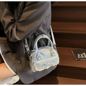 Detail der hellblauen Handtasche mit Schleife, Spitze und Band auf Vintage-Holzhintergrund