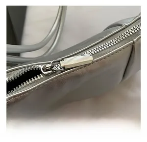 Detail view of the silver metallic dumpling bag featuring high-quality alloy zipper closure