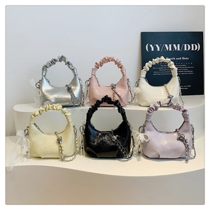 Détail de sacs à main nuage colorés au fini brillant avec ornements de nœuds en perles