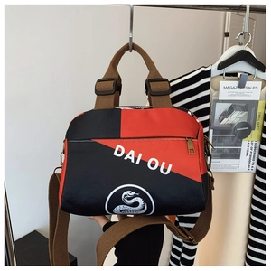 Détail du sac à main en nylon rouge et noir imperméable avec logo imprimé DAI OU blanc
