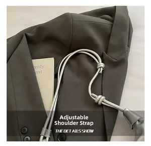 Detail view showing adjustable silver shoulder strap with knotted design and metallic texture