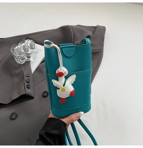 Vue détaillée du sac pour téléphone bleu cyan avec pendentif canard et texture litchi grainée