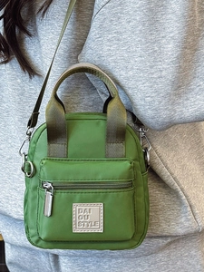 Chic grass green nylon crossbody bag for women featuring a front zipper pocket and strap