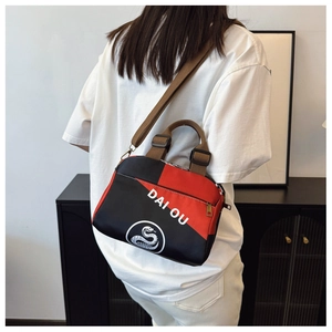 Vue arrière d'un sac bandoulière rouge et noir avec sangle réglable sur un mannequin