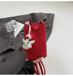 Détail de la pochette téléphone rouge en cuir grainé avec charmant petit canard blanc