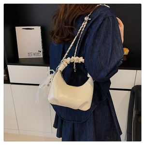 Détail du sac nuage blanc crème avec poignée plissée, chaîne en métal et pendentif perle