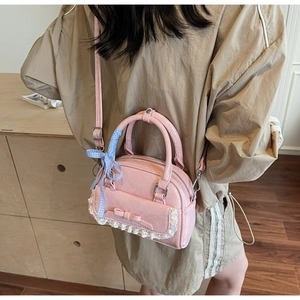 Rosa Schleifen-Handtasche mit Spitze und Band-Detail am Model zur Größendarstellung