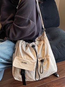 Minimalist cream white drawstring crossbody bag with large capacity and logo pocket