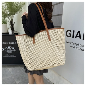 Detailed view of beige woven tote bag texture with elegant brown faux leather handles