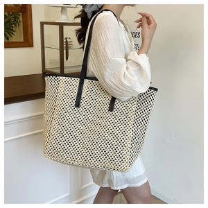 Detail of French style woven tote bag showing side view with long black shoulder straps