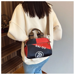 Détail d'un sac bandoulière en nylon imperméable tricolore avec logo imprimé DAI OU