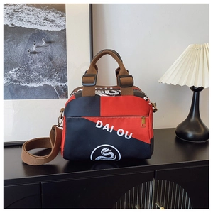 Détail du sac cabas en nylon multicolore avec logo serpent et bandoulière marron