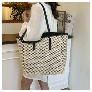 Close-up showing the woven texture and black leather strap detail of the beach tote bag