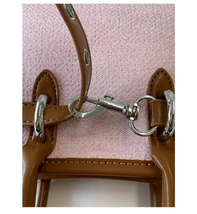Detailed view of silver metal buckle on premium pink textured fabric with brown leather strap