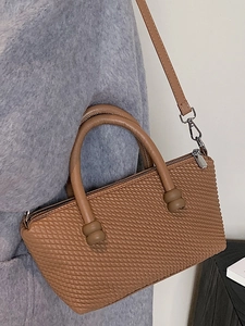 Fashionable caramel brown woven handbag with crossbody strap and silver zipper closure