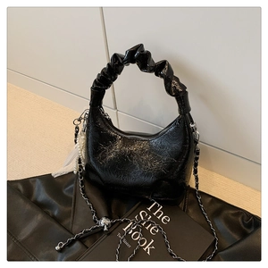 Détail du sac nuage noir plissé avec finition brillante et chaîne de perles