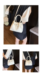 Close-up detail of cream white bucket bag with striped weave texture and buckle strap
