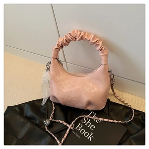 Détail du sac en cuir verni rose avec poignée nuage, chaîne argentée et charms en perles